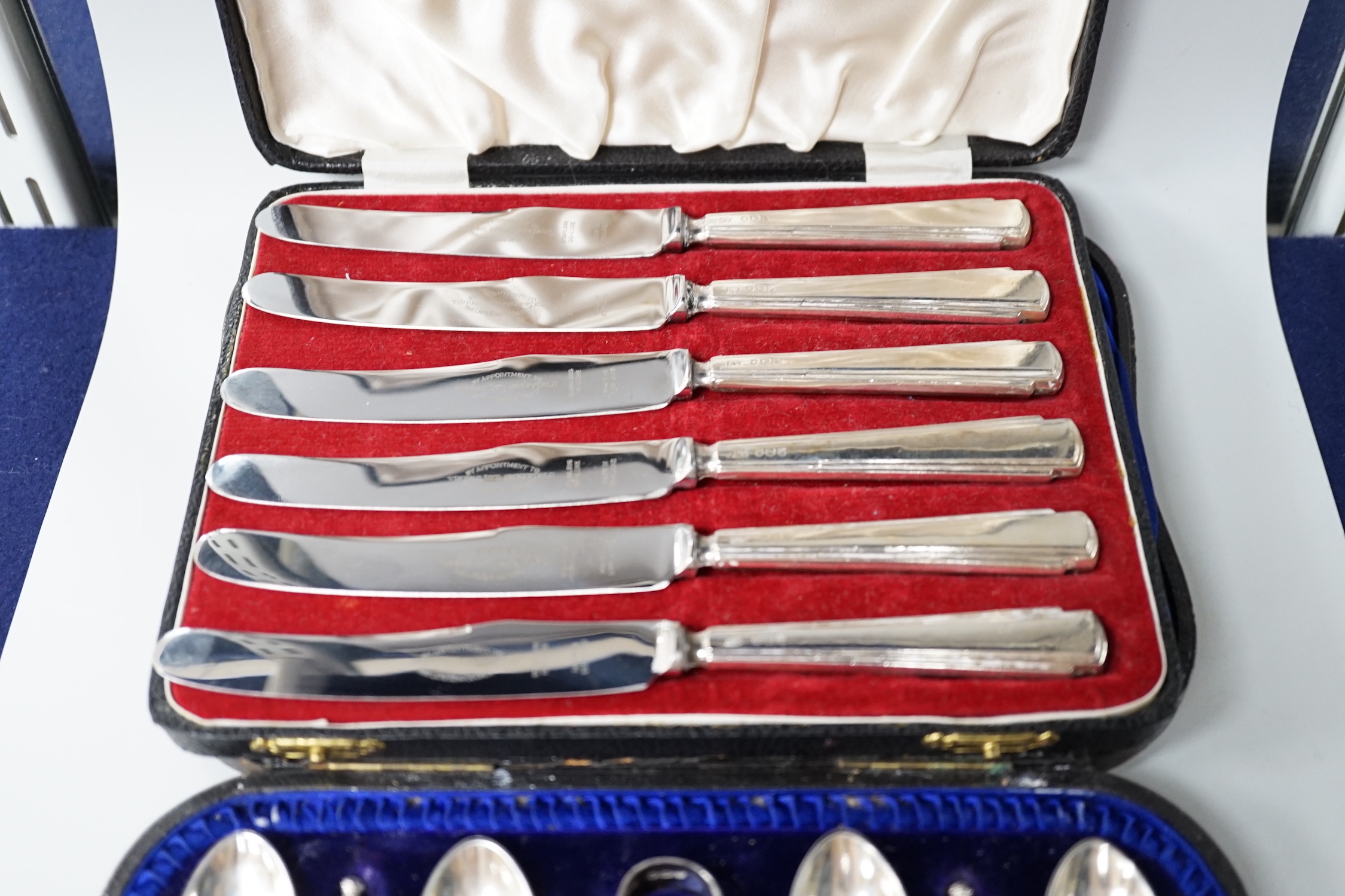 A cased set of six late Victorian silver apostle teaspoons and tongs, Sheffield 1900, 116 grams, and a set of six George VI silver handled cake knives, Sheffield 1957